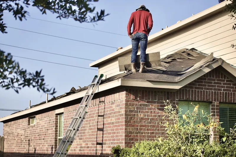 Professional roofer working on a residential roof in Greason